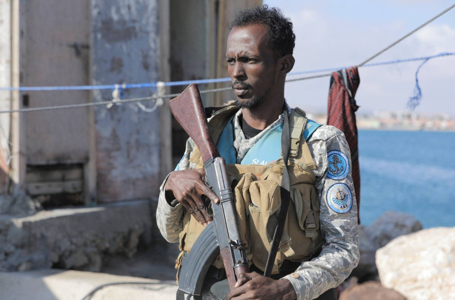 أحد أفراد قوة الشرطة البحرية يقف للحراسة على ساحل بوساسو في منطقة بونتلاند شبه المستقلة بالصومال (رويترز)