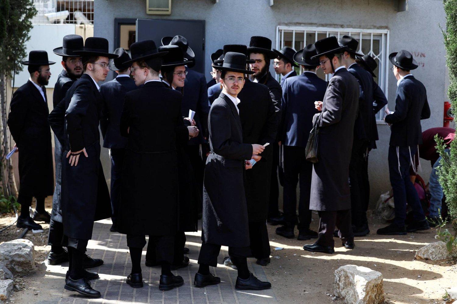 يهود متدينون يصطفون في مكتب تجنيد إسرائيلي لمعالجة إعفاءاتهم من الخدمة العسكرية الإلزامية في قاعدة تجنيد في كريات أونو بإسرائيل في 28 مارس 2024 (رويترز)