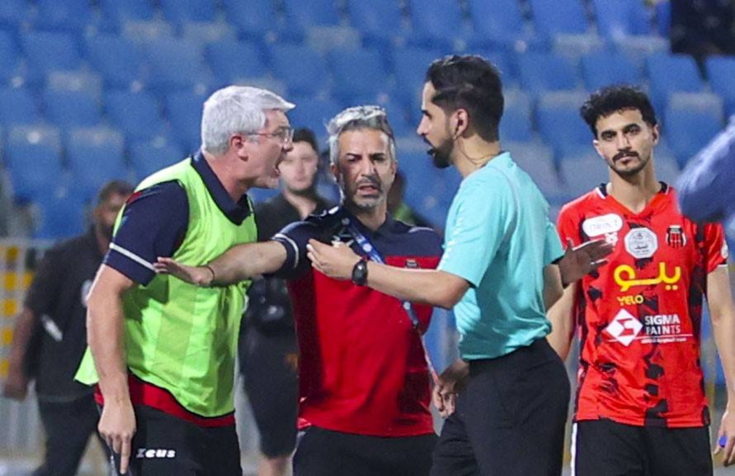 هيلمان مدرب فريق الرياض في حديث مع حكم اللقاء قبل حالة الطرد له (تصوير: سعد الدوسري)