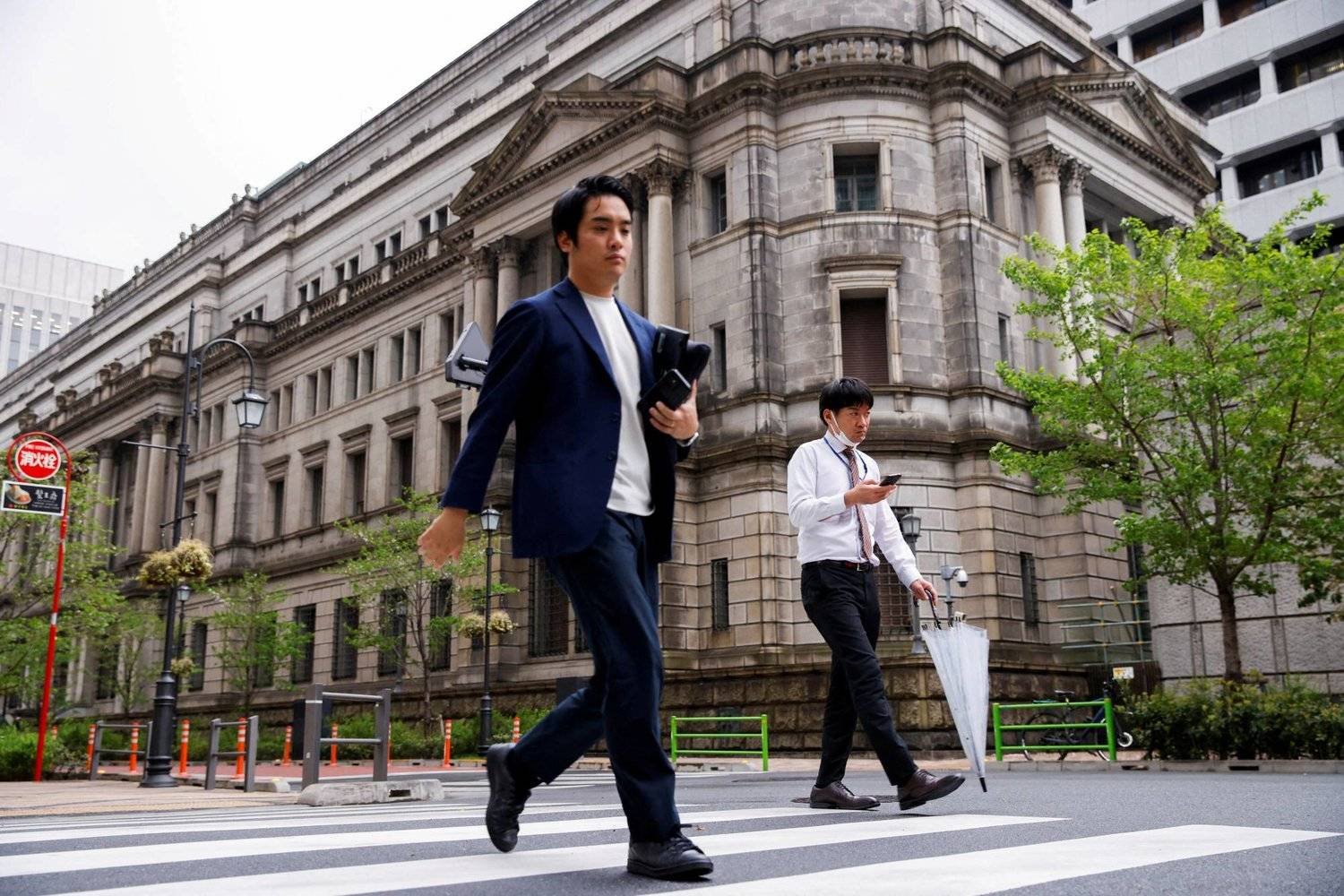 مشاة يمرّون أمام مقر «البنك المركزي» وسط العاصمة اليابانية طوكيو (رويترز)