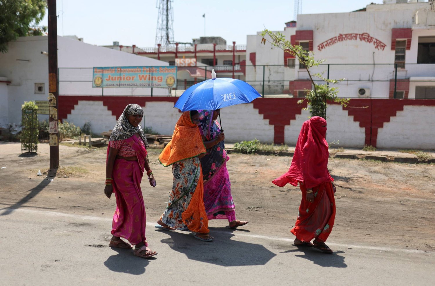 ناخبات يحتمين من الحرارة بعد إدلائهن بأصواتهن في أوتار براديش، الجمعة (رويترز)