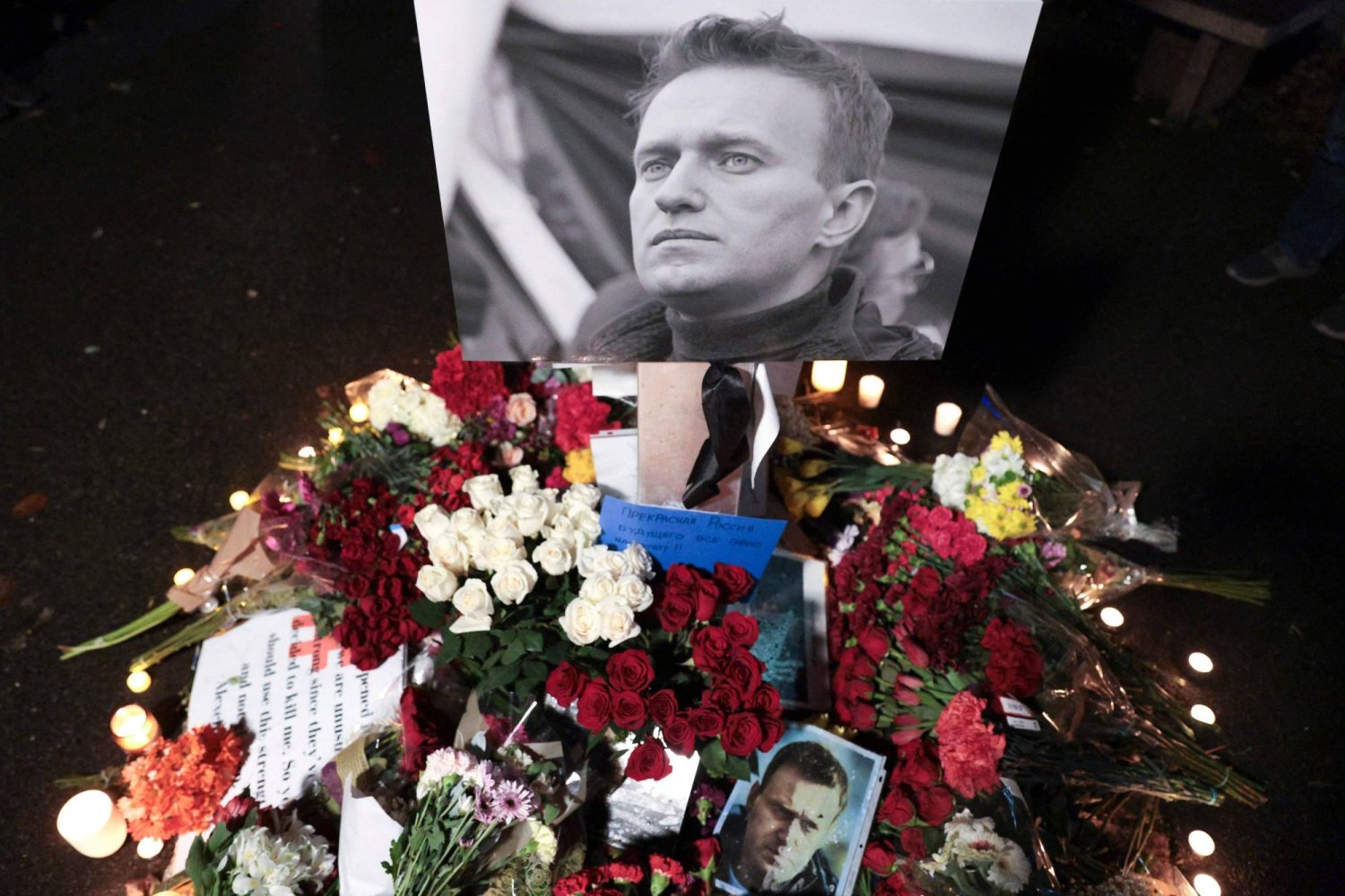 صورة المعارض الروسي أليكسي نافالني تتوسط باقات الزهور أثناء مراسم تأبينه (أ.ف.ب)