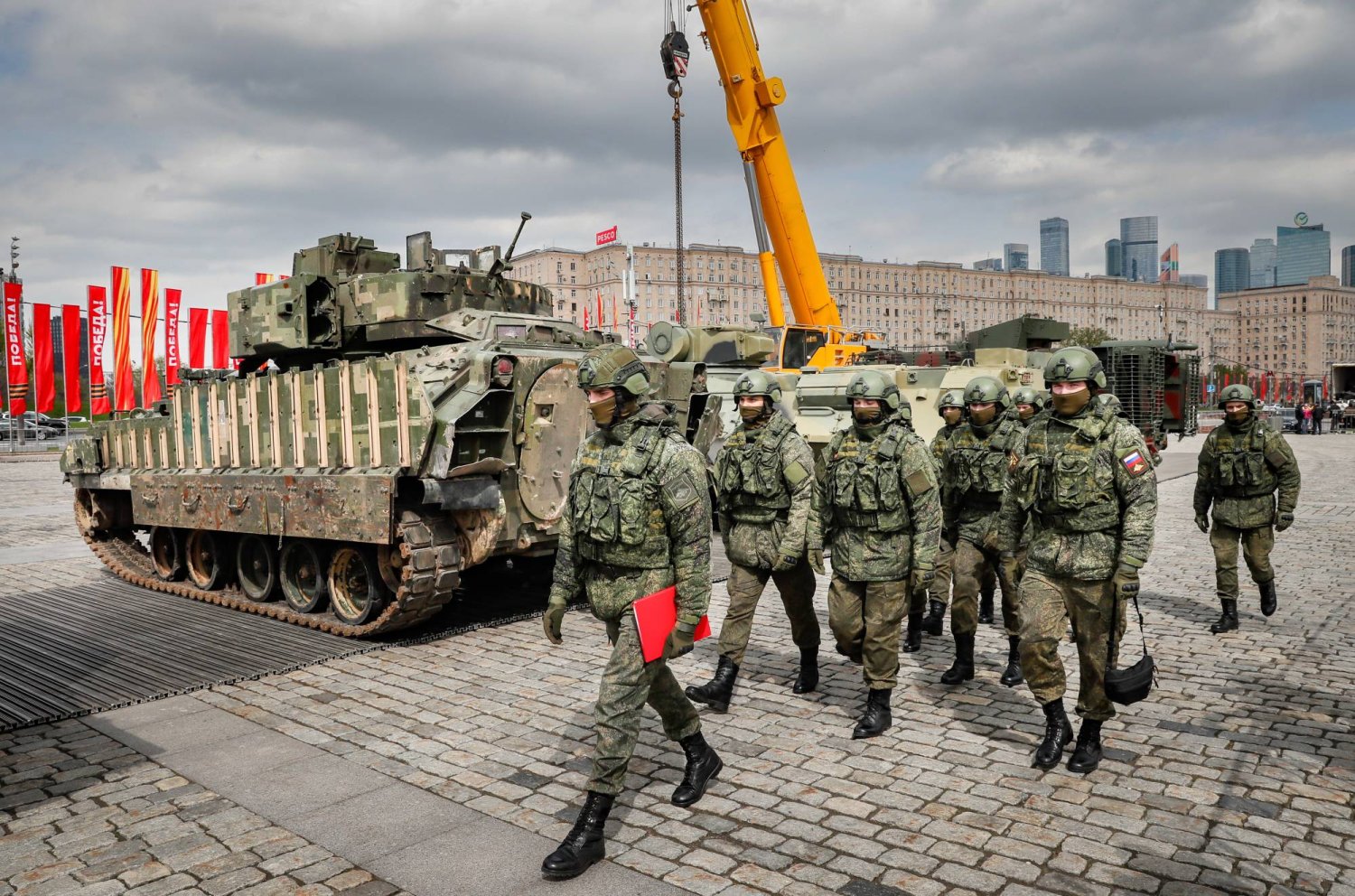 جنود روس يمرون بمركبة مشاة قتالية أميركية الصنع من طراز M2 برادلي استولت عليها القوات الروسية خلال عملية عسكرية خاصة في أوكرانيا (إ.ب.أ)