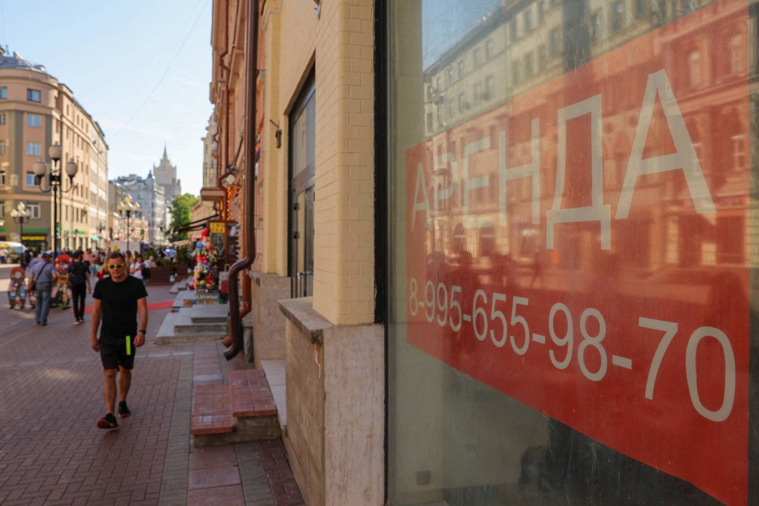 أحد المشاة يسير بمحاذاة نوافذ المباني التجارية للإيجار في موسكو بروسيا (رويترز)