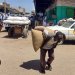 سوداني يحمل كيساً من الحبوب يوم الأربعاء في مدينة القضارف شرق السودان (أ.ف.ب)