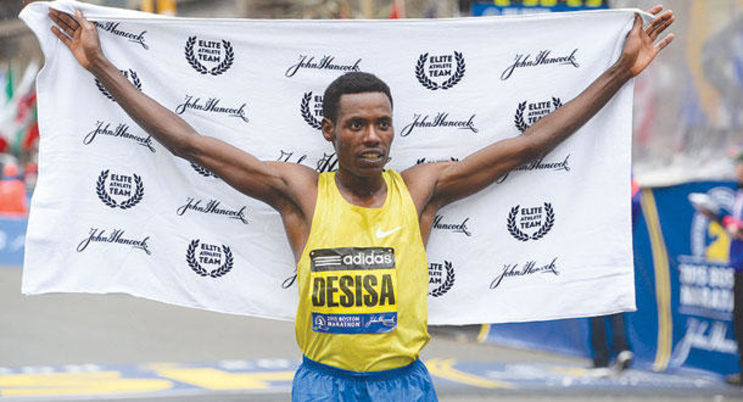 الإثيوبي ديسيسا يحتفل بعد فوزه بماراثون بوسطن (إ.ب.أ)