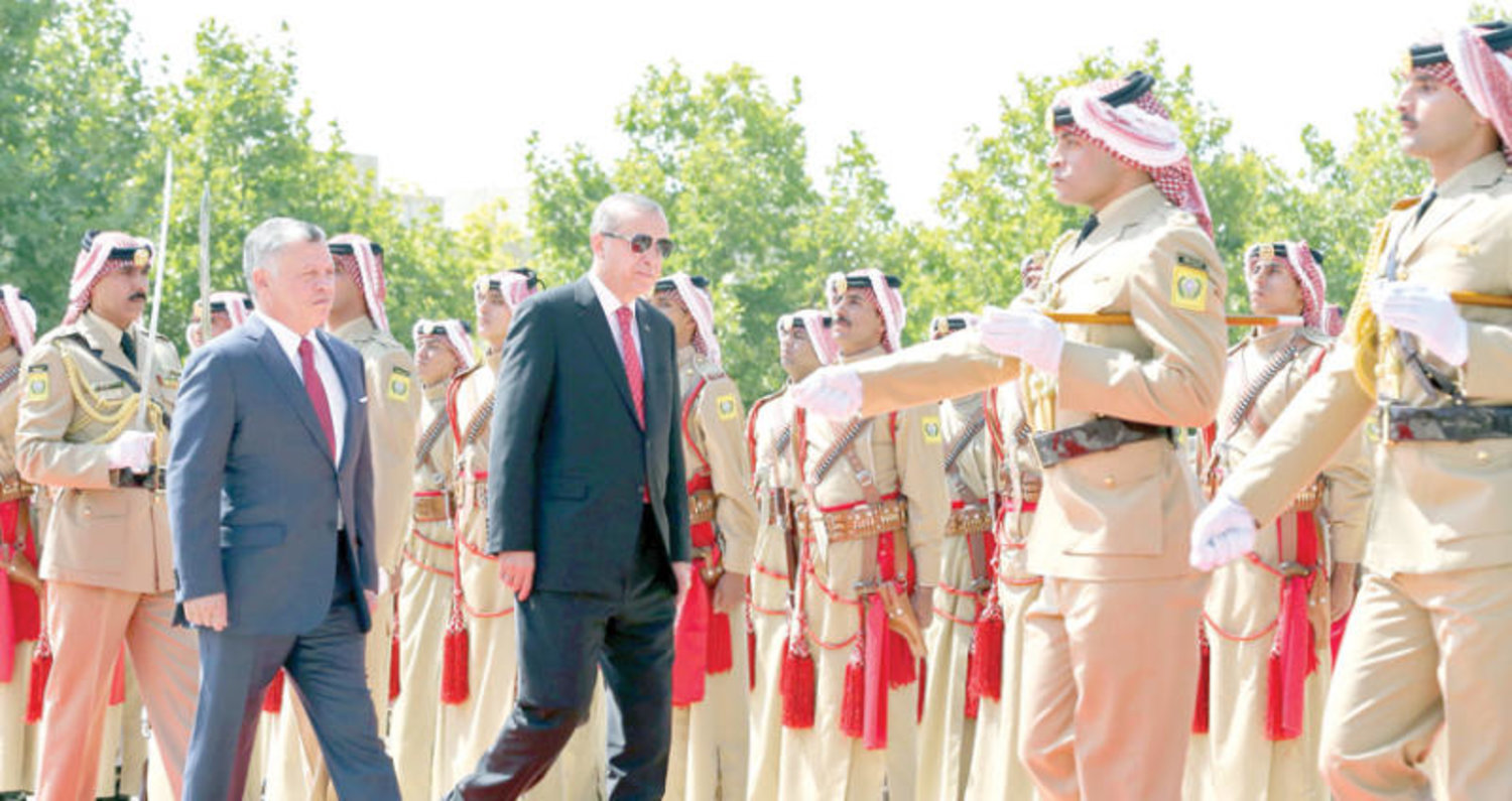 العاهل الاردني الملك عبد الله الثاني والرئيس التركي رجب طيب أردوغان يستعرضان حرس الشرف في القصر الملكي في عمان أمس (أ.ف.ب)