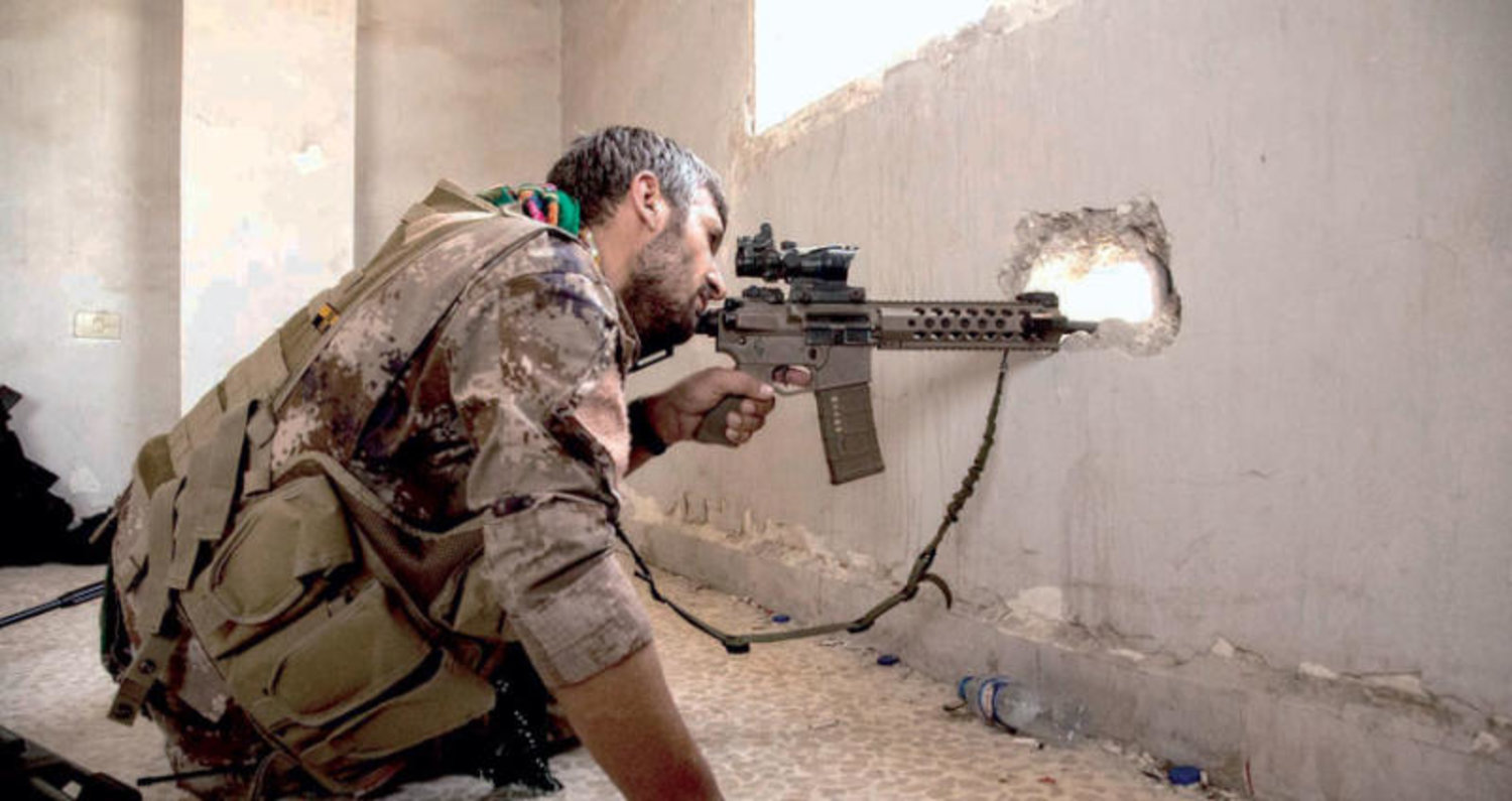 مقاتل كردي في حي المنصور في الرقة أمس (حملة غضب الفرات)