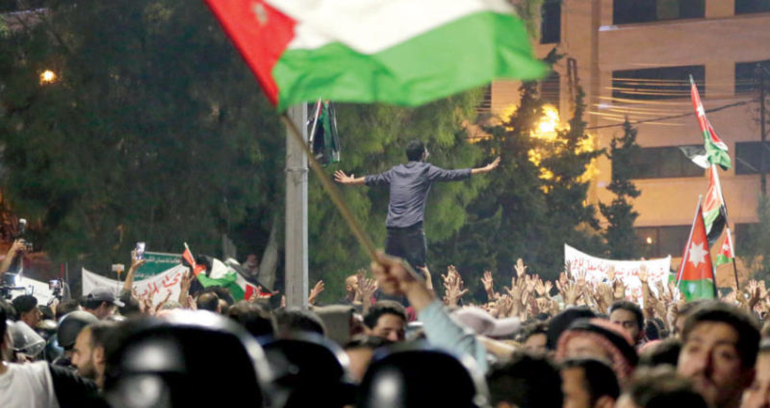 محتجون يرفعون أعلاماً أردنية خلال مظاهرة في عمان أول من أمس (إ.ب.أ)