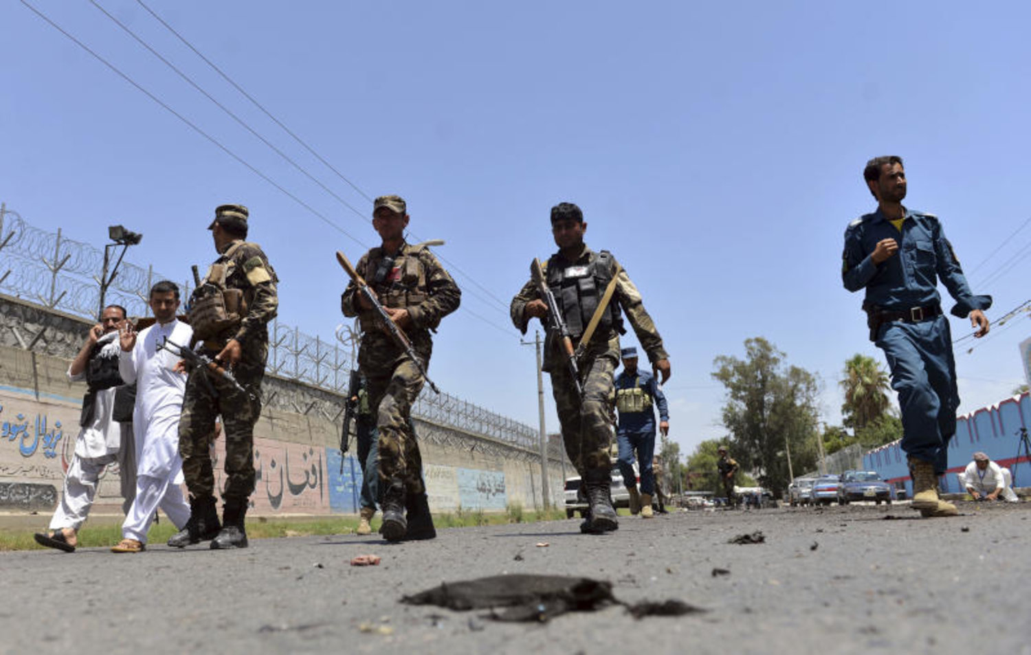 وصول أفراد الأمن الأفغاني إلى موقع الهجوم الانتحاري في مدينة جلال آباد شرق كابل (أ.ب)