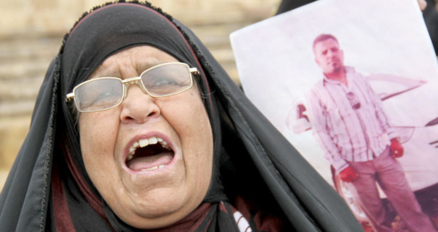 عراقية تحمل صورة قريبها الذي كان محتجزاً لدى «داعش» خلال تجمع في مدينة الموصل الشهر الماضي (أ ف ب)