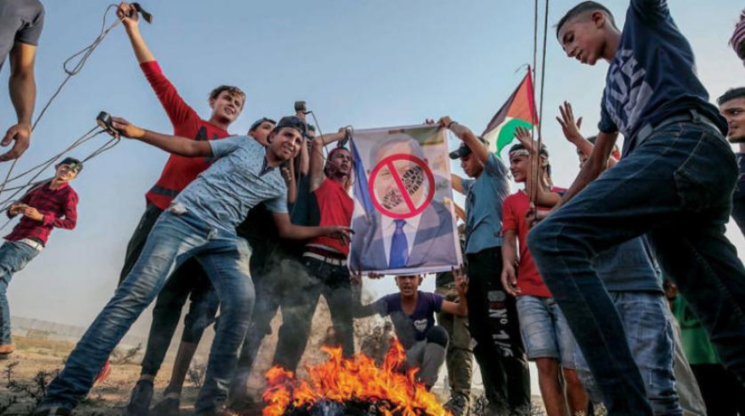Filistinli vatandaşlar cuma günü Gazze’de düzenlediği gösterilerde İsrail Başbakanı Binyamin Netanyahu’nun fotoğrafı yakıyor (EPA)