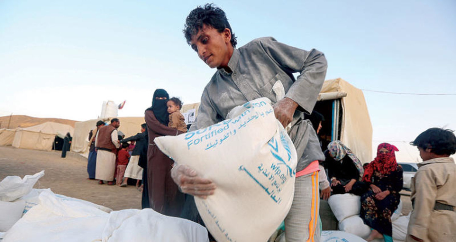 يمني يحمل مساعدات تقدم للنازحين من محافظة الجوف إلى مأرب (رويترز)