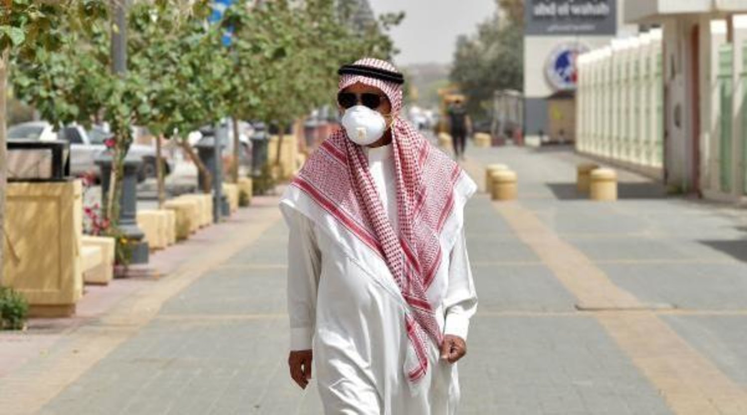 مواطن سعودي يرتدي كمامة واقية يسير في أحد شوارع الرياض (أ.ف.ب)