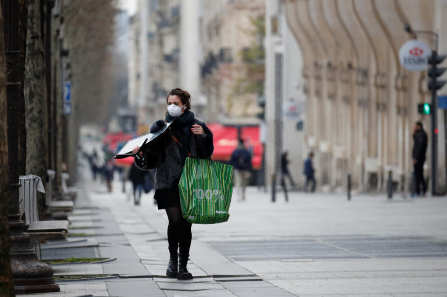 سيدة ترتدي قناعا واقيا في باريس تجنبا لفيروس «كورونا» (رويترز)