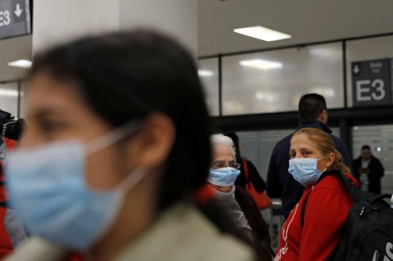 مسافرون يضعون كمامات طبية عند وصولهم إلى مطار بينيتو خواريز الدولي في مكسيكو سيتي (رويترز)