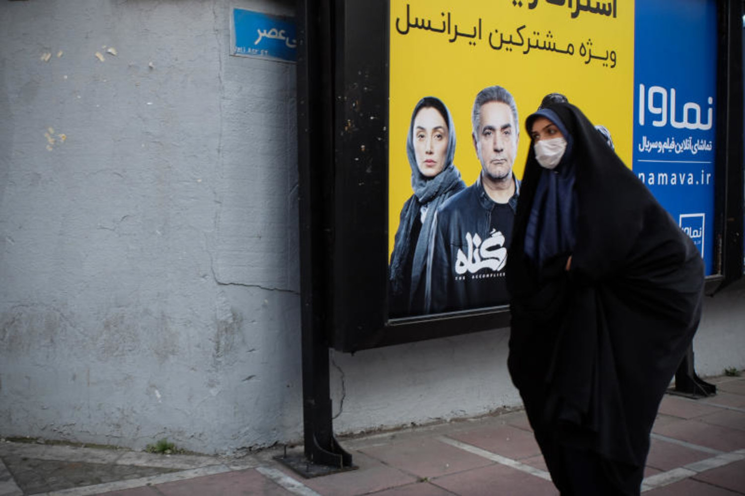 سيدة ايرانية ترتدي قناع وقاية تسير في احد شوارع طهران(د.ب.أ)
