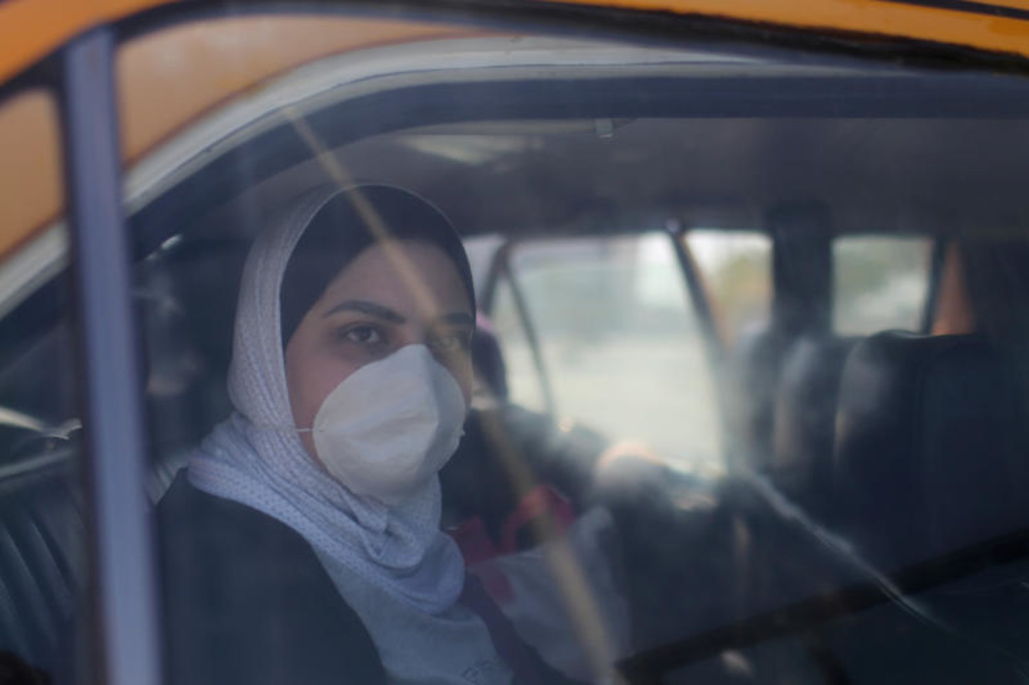 سيدة فلسطينية تضع قناع وقاية  داخل سيارة أجرة فى غزة (رويترز)