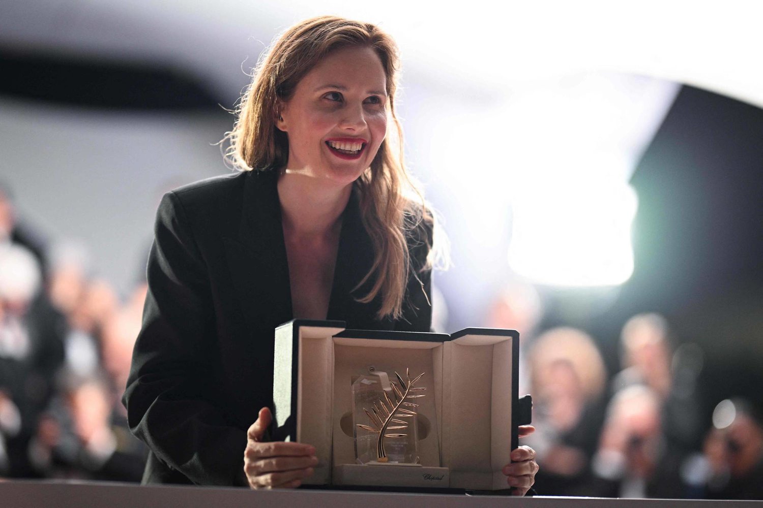 المخرجة الفرنسية جوستين ترييه تحمل جائزة السعفة الذهبية (أ.ف.ب)
