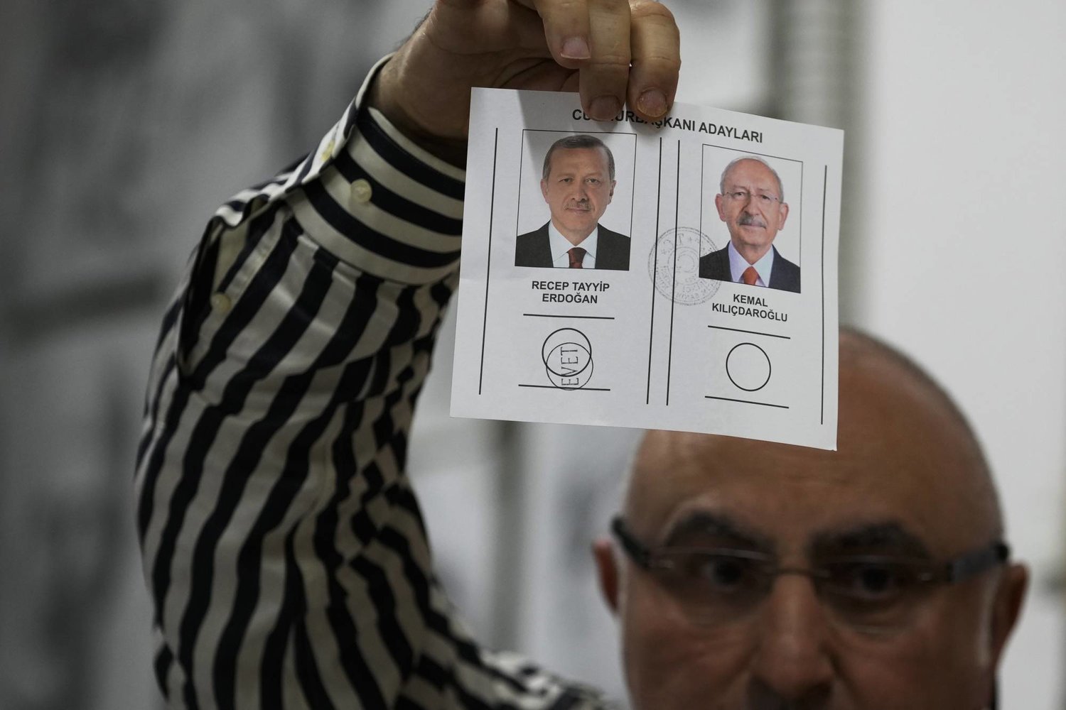 مندوب يعرض ورقة تصويت لمصلحة إردوغان في مركز اقتراع بإسطنبول الاثنين (أ.ب)