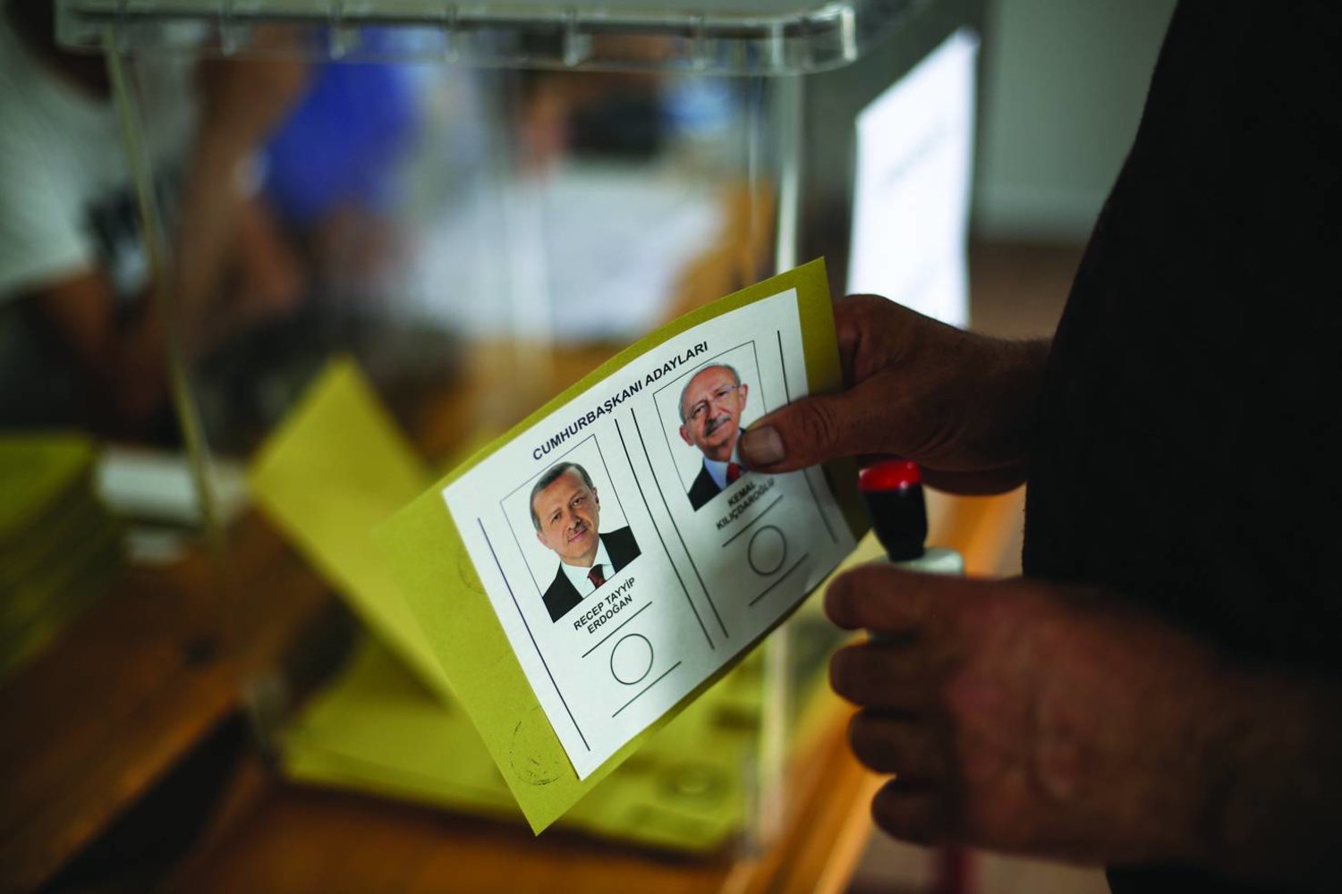ناخب يحمل بطاقة اقتراع في انتخابات الرئاسة التركية (أ.ب)
