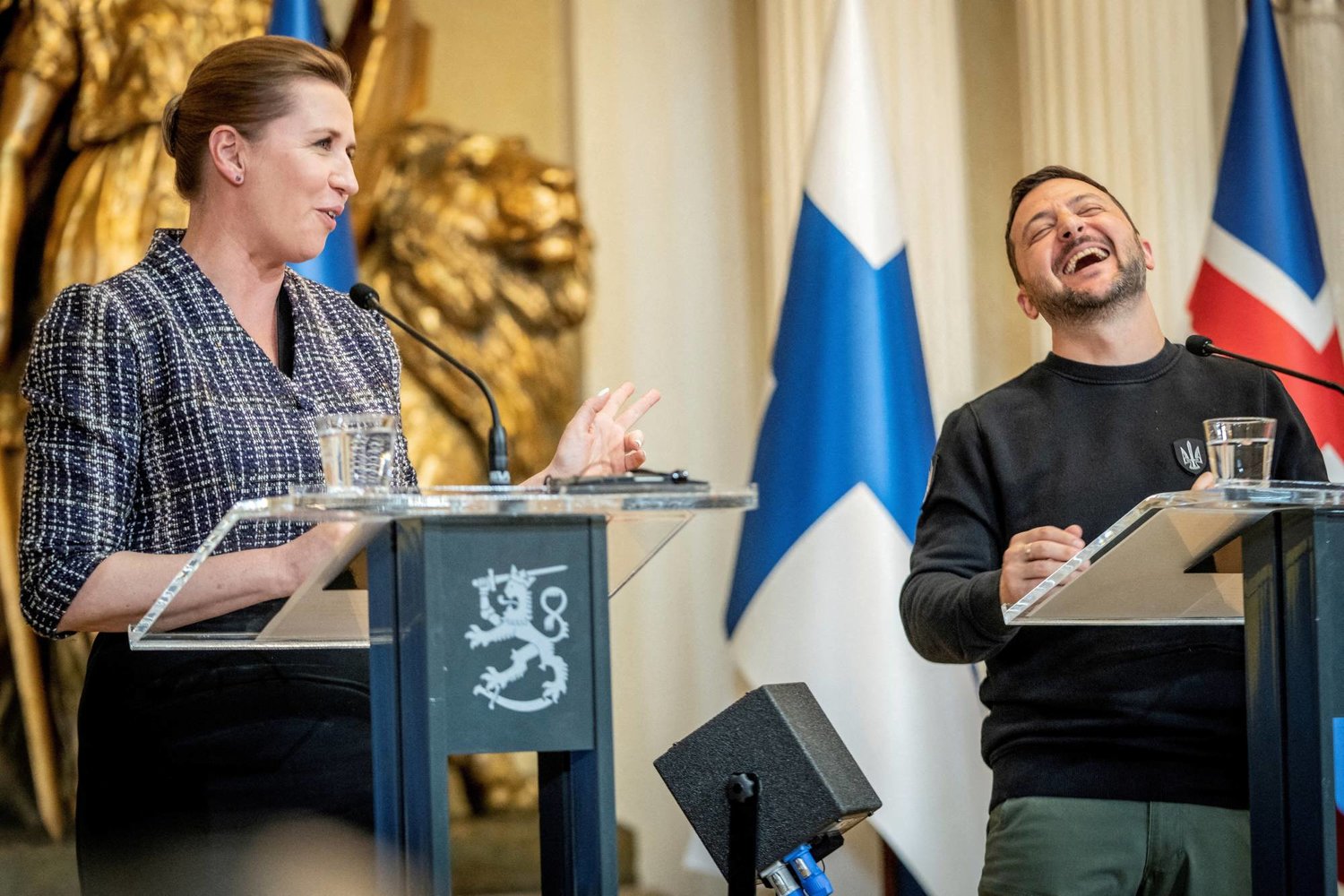 رئيسة وزراء الدنمارك ميتي فريدريكسن والرئيس الأوكراني فولوديمير زيلينسكي يضحكان في مؤتمر صحافي مع رؤساء دول الشمال الأوروبي خلال قمة الشمال الأوكراني في القصر الرئاسي بهلسنكي 3 مايو 2023 (رويترز)