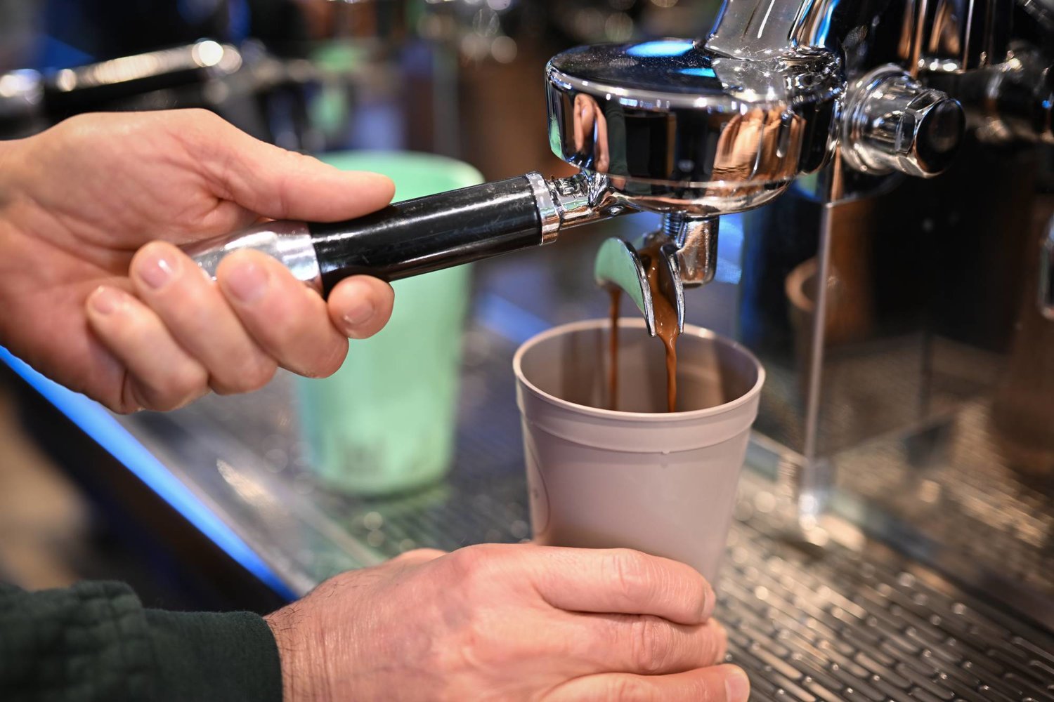 موظف يعد القهوة في أحد المقاهي في ألمانيا (د.ب.أ)