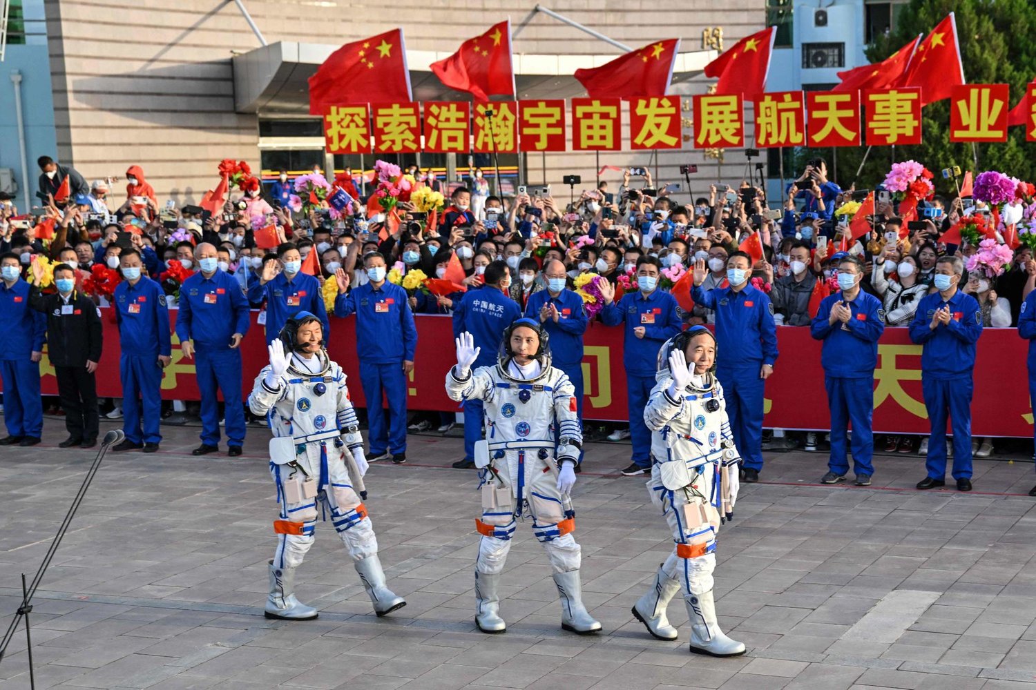 رائد الفضاء المخضرم جينغ هابينغ والمهندس جو يانغجو وغي هايشو أول مدني يذهب للفضاء (أ.ف.ب)