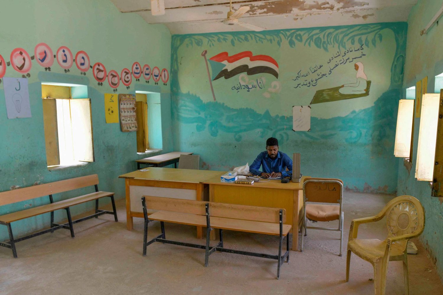 متطوع سوداني يعمل في غرفة طوارئ ضمن مبنى مدرسة تحول إلى مستشفى في أم درمان (أ.ف.ب)
