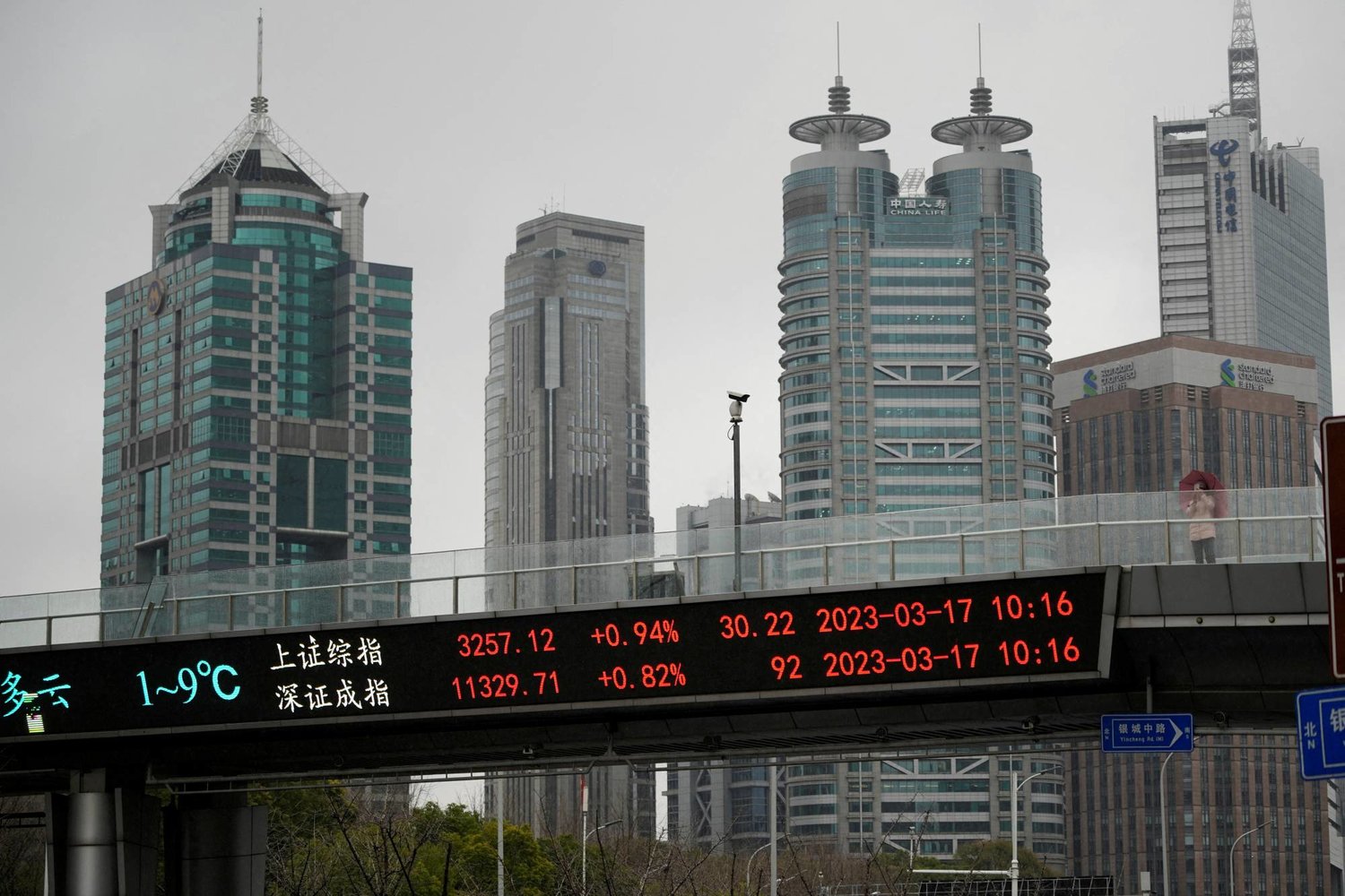 شاشة ضخمة على أحد الجسور في مدينة شنغهاي الصينية تعرض حركة الاسهم على مؤشري شنغهاي وشينزن (رويترز)