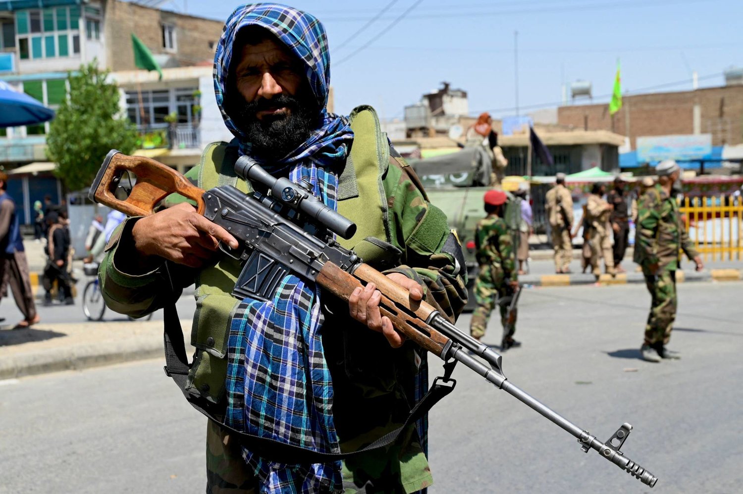 أفراد أمن «طالبان» يقفون حراساً وآخرون يغلقون الطريق بينما يسير المعزون خلال موكب في اليوم العاشر من عاشوراء (أ.ف.ب)