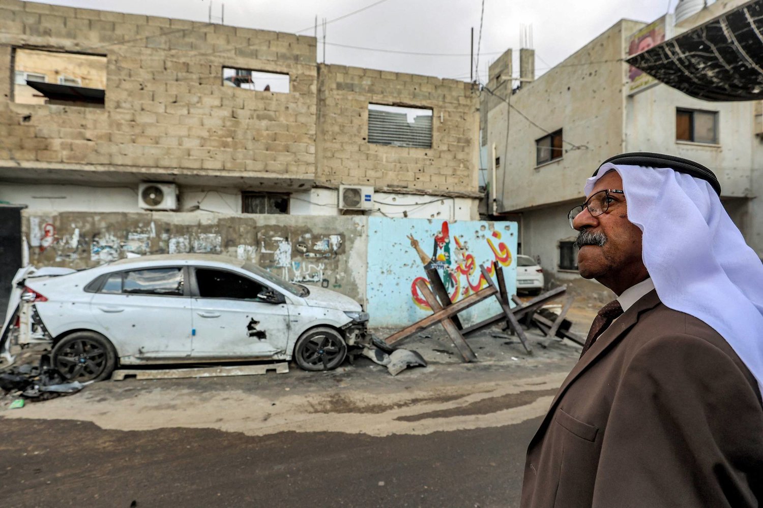 مواطن فلسطيني أمام أضرار اجتياح إسرائيلي آخر لمدينة جنين ومخيمها (أ.ف.ب)
