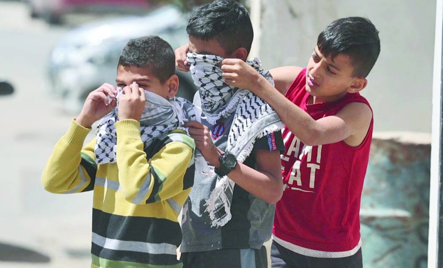 أطفال فلسطينيون يغطون وجوههم بالكوفية خلال تصدي جنين لاجتياح سابق (أ.ف.ب)