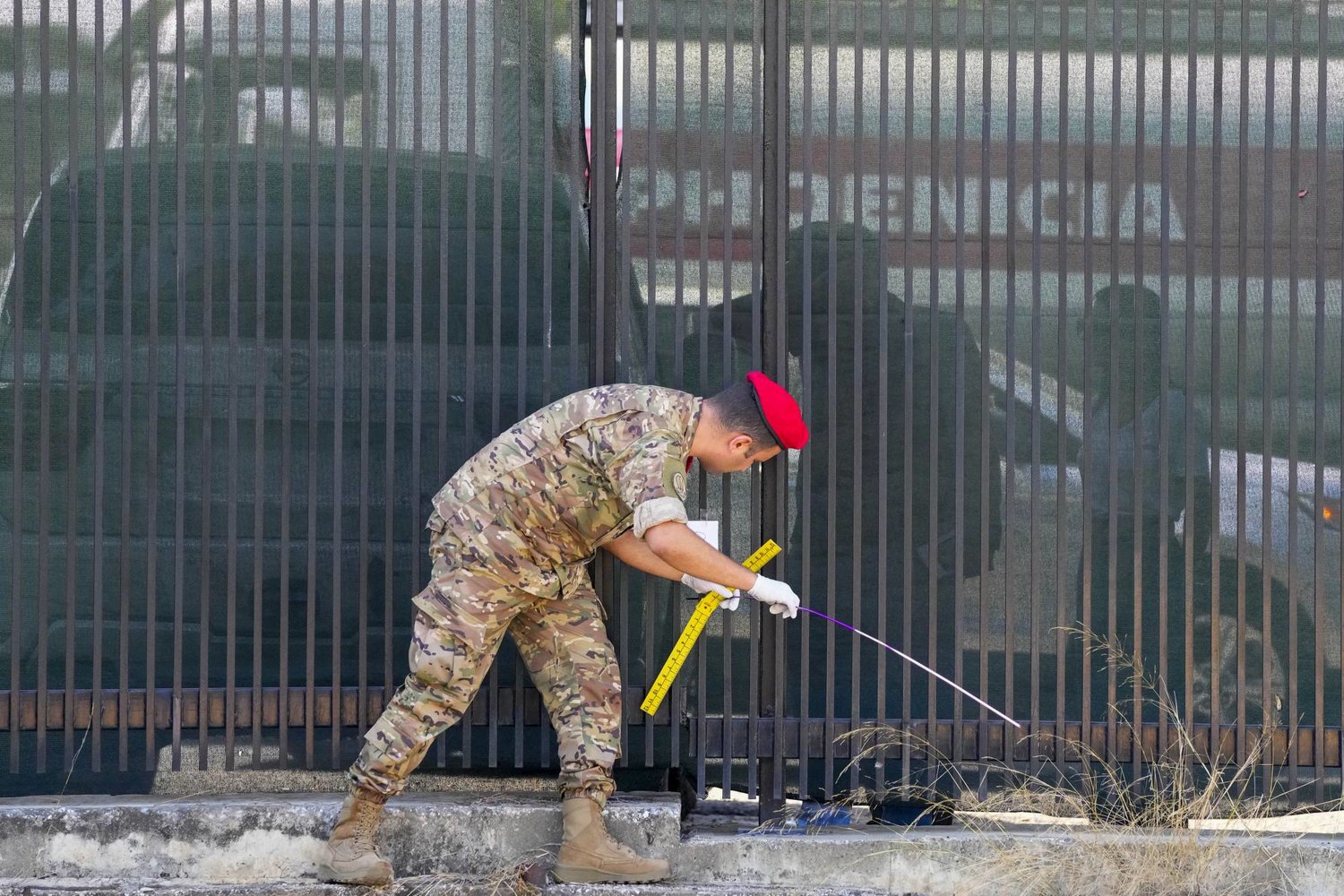 جندي لبناني أثناء جمع الأدلة على مدخل السفارة الأميركية في عوكر (أ.ب)
