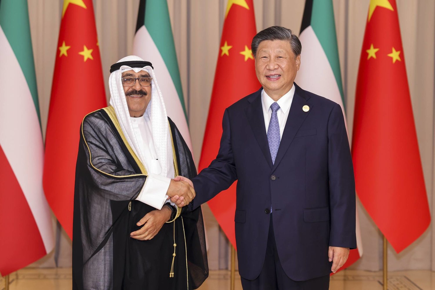 الرئيس الصيني شي جينبينغ (على اليمين) يصافح ولي عهد الكويت الشيخ مشعل الأحمد الجابر الصباح قبل اجتماعهما الثنائي في هانغتشو الصين (وكالة أنباء شينخوا)
