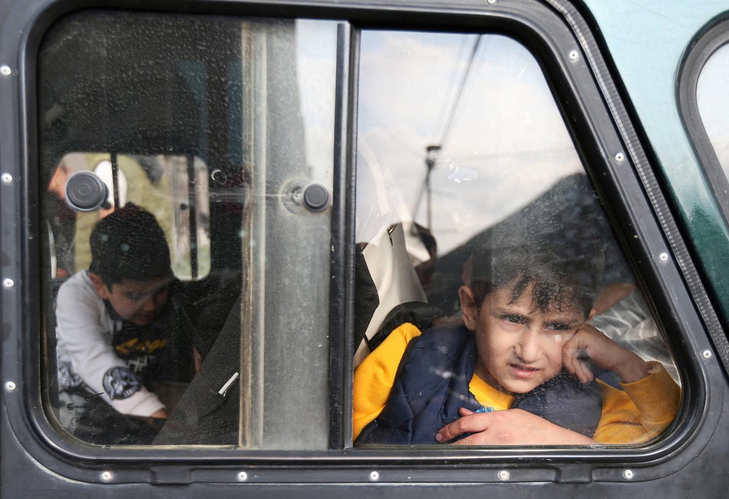 صبي لاجئ من منطقة ناغورنو كاراباخ ينظر من نافذة السيارة عند وصوله إلى مركز إقامة مؤقت في بلدة غوريس بأرمينيا (رويترز)