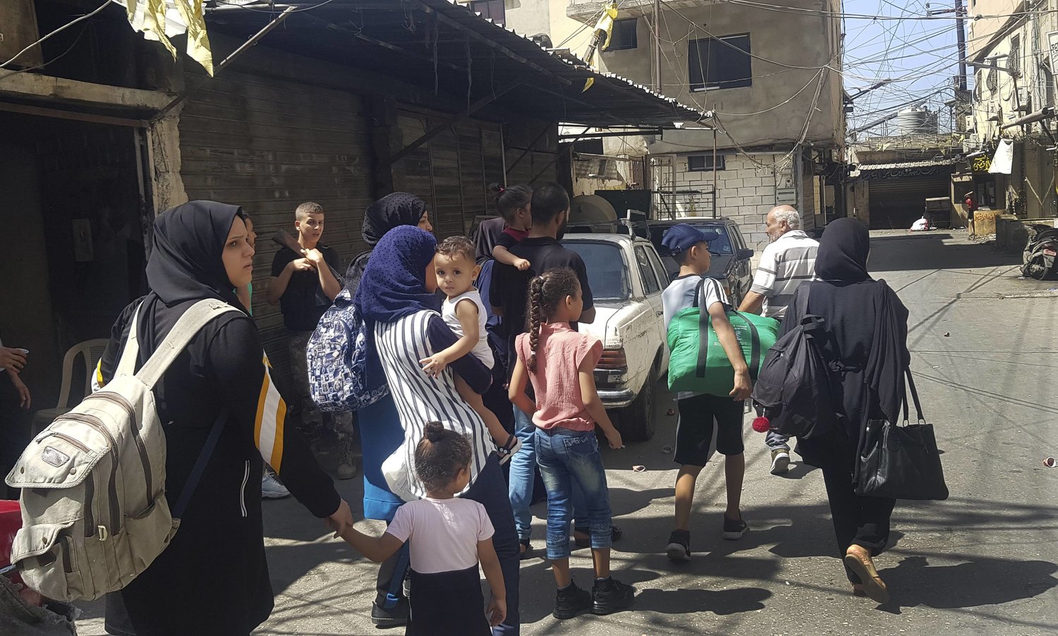 نساء وأطفال أثناء الهروب من الاشتباكات في عين الحلوة في 17 سبتمبر (أ.ب)