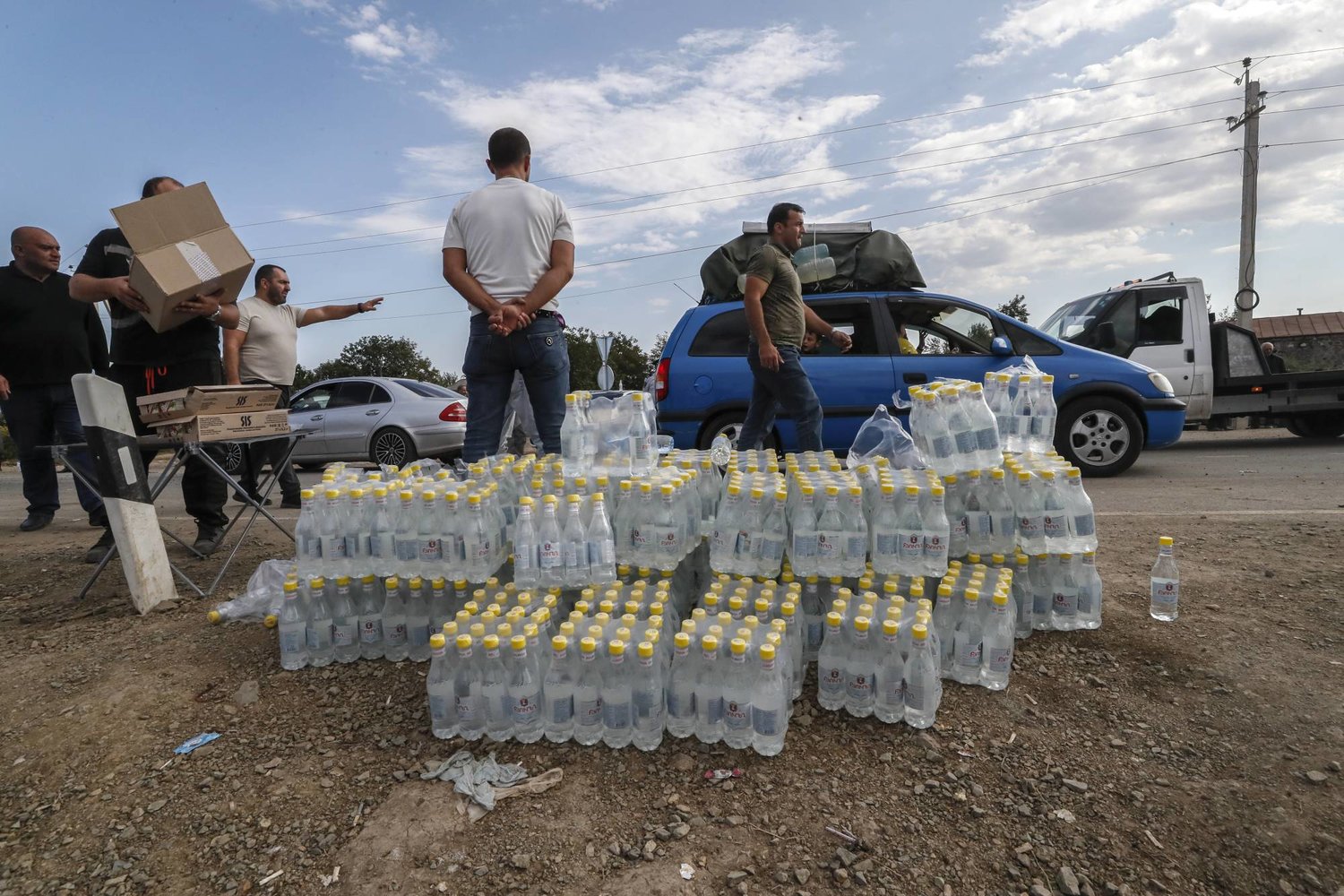 متطوعون يقدمون الماء والطعام للأرمن الفارين من كاراباخ إلى أرمينيا، الخميس (إ.ب.أ)