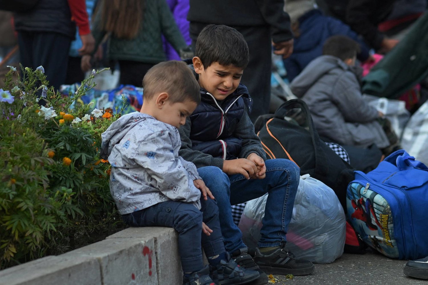 أطفال يجلسون على الرصيف، بينما يتجمع سكان وسط ستيباناكيرت لمغادرة ناغورنو كاراباخ التي يسكنها أرمن، 25 سبتمبر 2023 (رويترز)