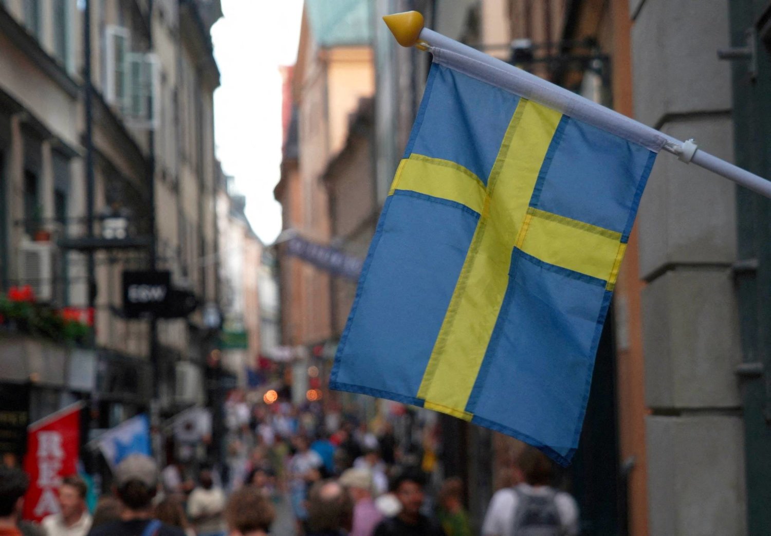علم السويد في أحد شوارع أستوكهولم (رويترز)
