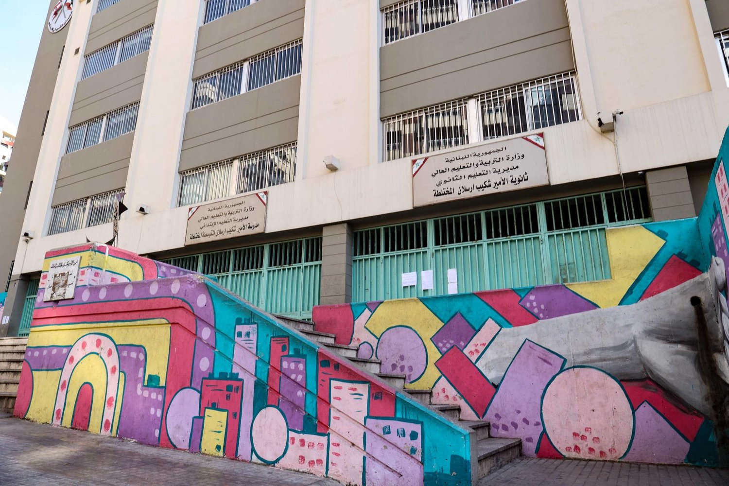 مدخل مدرسة رسمية مزين باللوحات الجدارية في بيروت (أ.ف.ب)