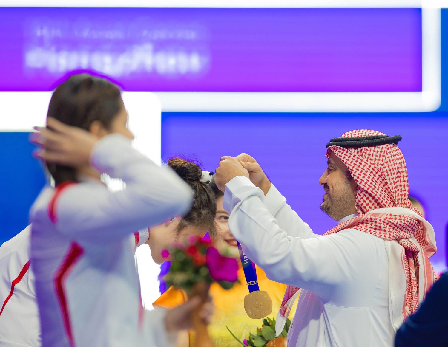 الأمير فهد بن جلوي لدى تتويجه الفائزات في مسابقة السباحة (الشرق الأوسط)