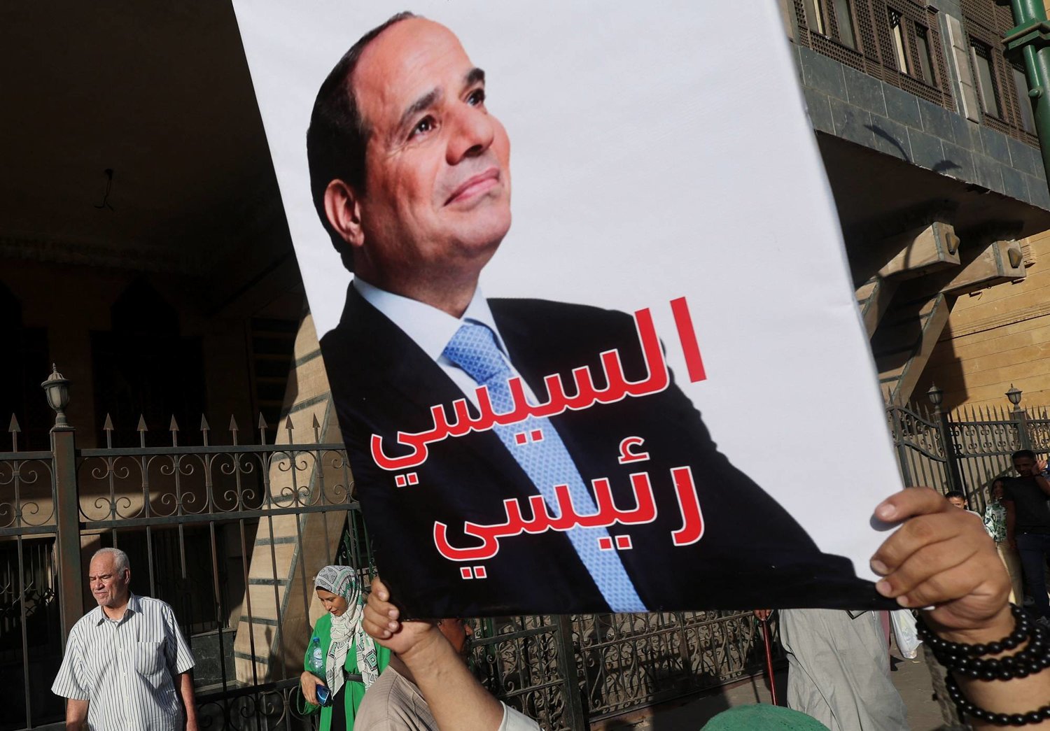 أحد أتباع «الطرق الصوفية» يحمل لافتة مؤيدة للسيسي خلال الاحتفال بالمولد النبوي في حي الأزهر بالقاهرة (رويترز)