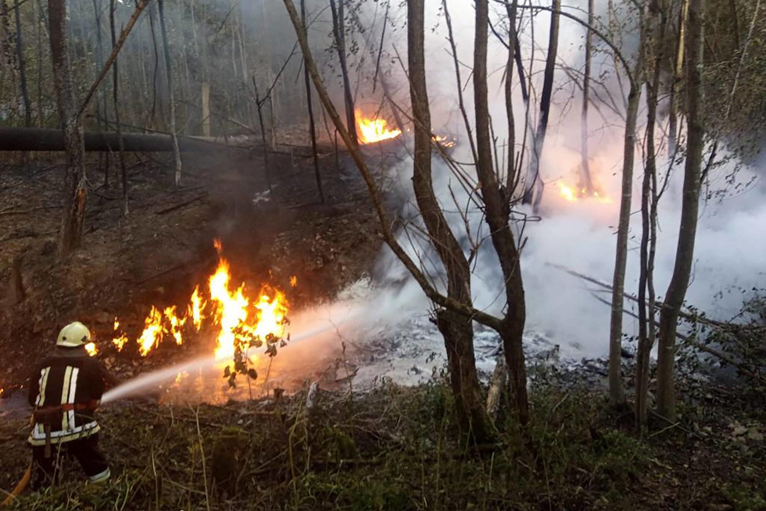  أحد  رجال الإنقاذ يعمل على إخماد الحريق الناجم عن انفجار في خط أنابيب النفط بالقرب من قرية ستريمبا (ا.ف.ب)