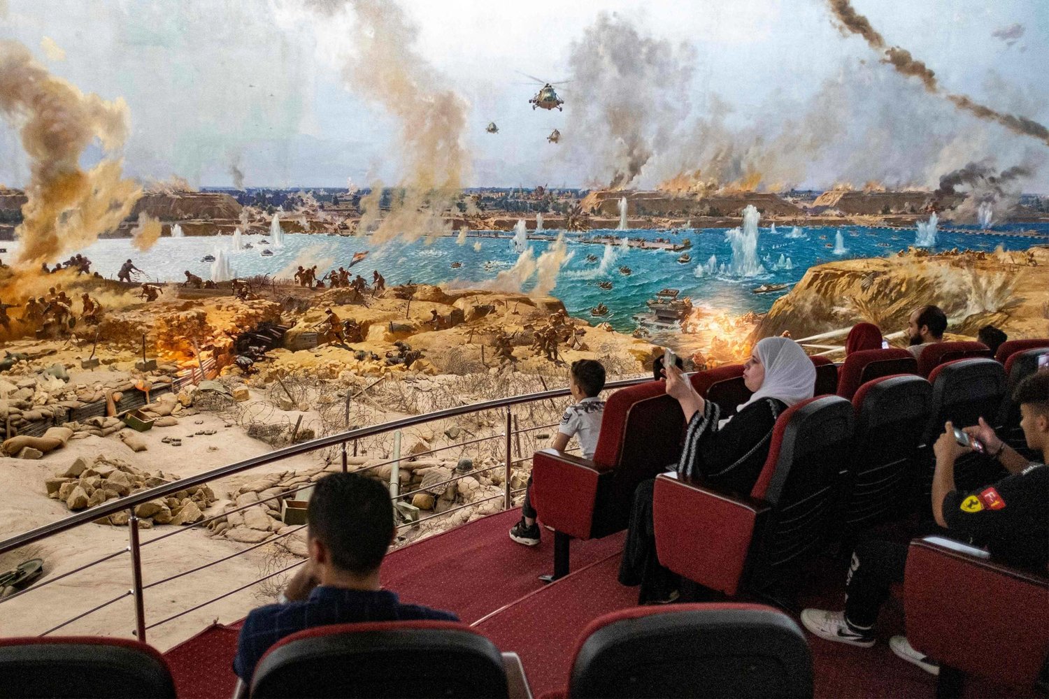أشخاص يحضرون عرضاً لمشهد حرب تمت إعادة إنشائه أثناء زيارة متحف «بانوراما حرب السادس من أكتوبر» بالقاهرة (أ.ف.ب)