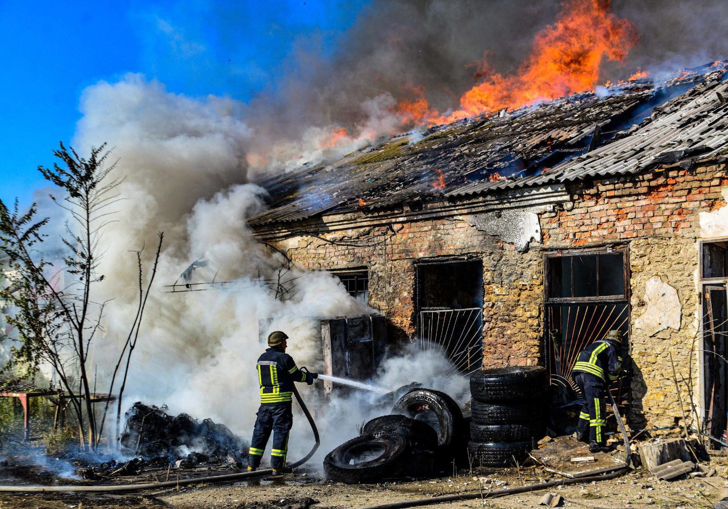 رجال الإطفاء وهم يقومون بإخماد حريق في أحد المستودعات بعد القصف في خيرسون منتصف الشهر الماضي (أ.ف.ب)