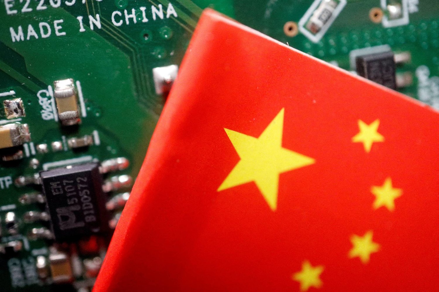 العَلم الصيني بجانب لافتة كُتب عليها «صنع في الصين» (رويترز)