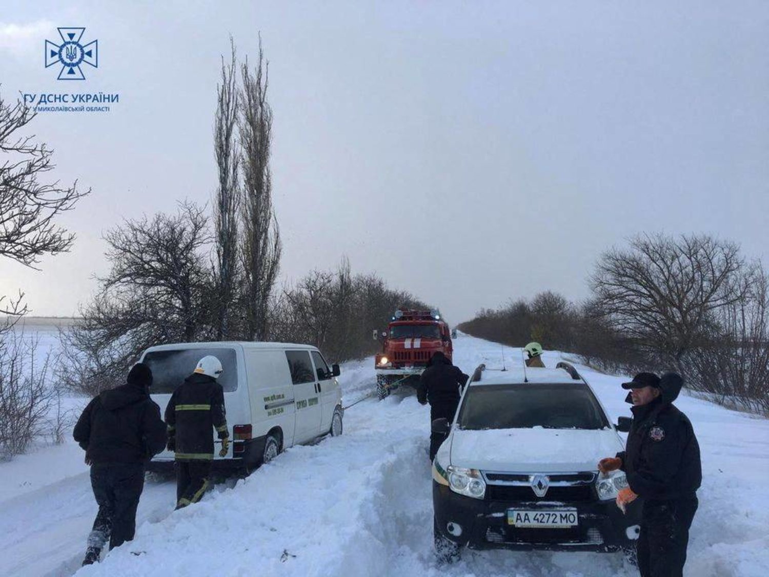 عمال الطوارئ ورجال الشرطة يساعدون أصحاب السيارات العالقة بالثلوج خلال عاصفة في منطقة ميكولايف (رويترز)