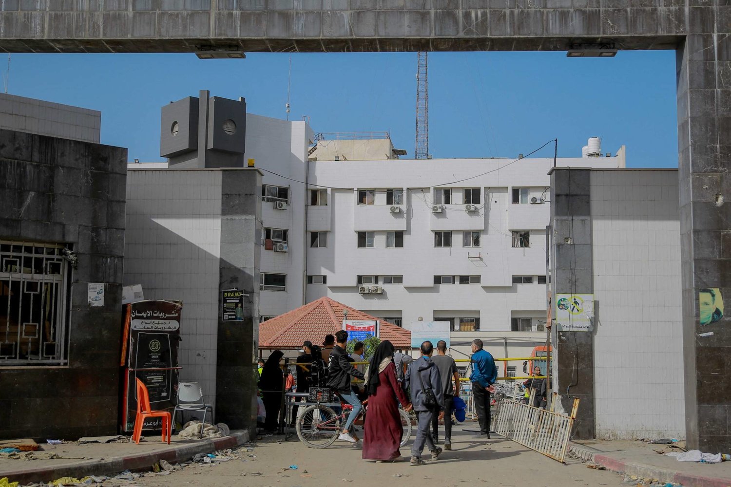فلسطينيون يمرون أمام مستشفى «الشفاء» بمدينة غزة في 26 نوفمبر 2023 في اليوم الثالث من الهدنة بين إسرائيل و«حماس» (أ.ف.ب)