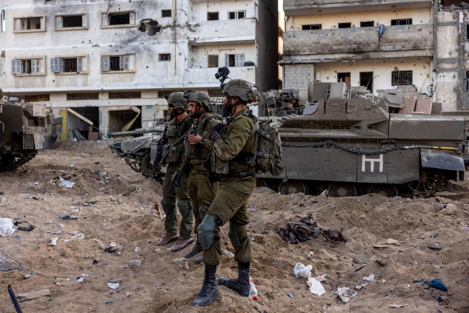 
جنود إسرائيليون يقفون وسط الأنقاض في مدينة غزة، (رويترز) 